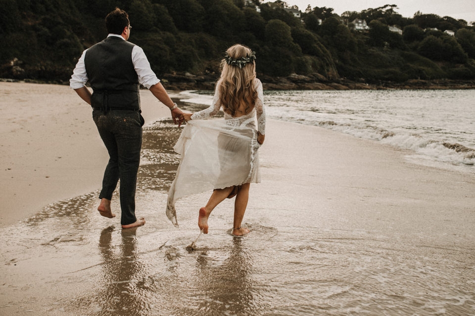 carbs bay st ives wedding day couple portraits , bride walking in the sea 